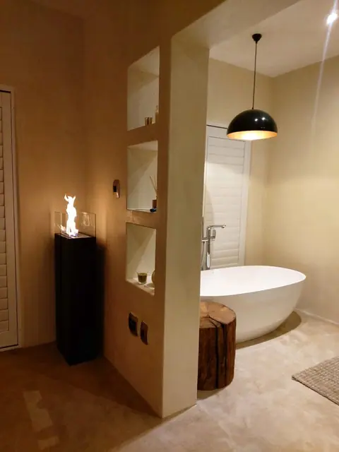 Open-plan en-suite with a free-standing bath behind a half wall