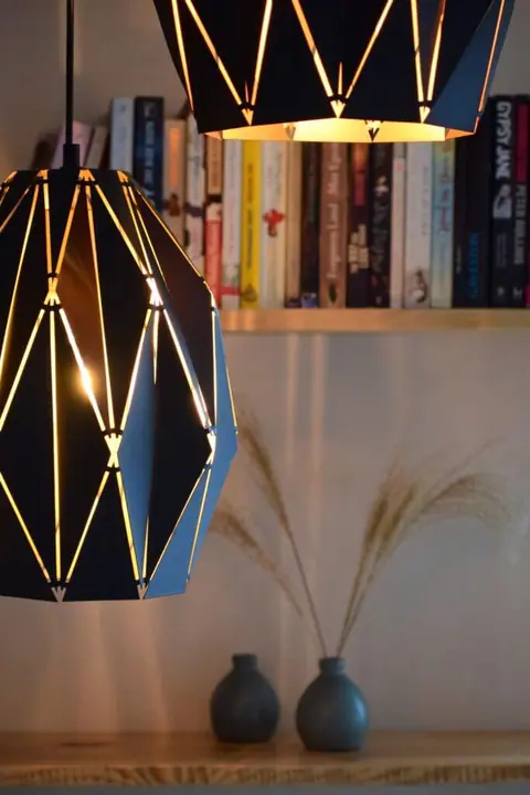 Geometric pendant lamps in front of a bookshelf