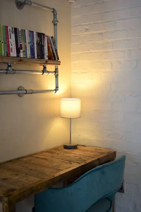 Wooden desk with a reading lamp and a teal chair
