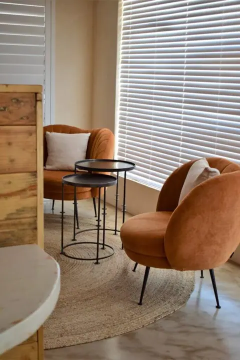 Rust-coloured armchairs in a sunny corner