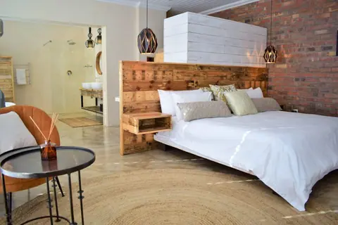 Suite with a king bed, reclaimed-wood headboard and armchair