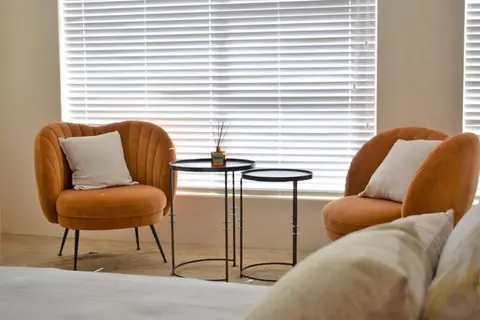 Pair of rust armchairs by the window