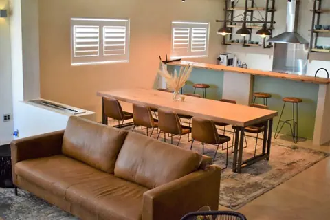 Long dining table and leather sofa in the living area